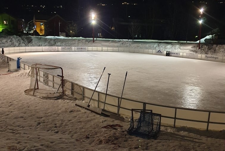 Utendørs isbane med isbat vant kveldsbilde